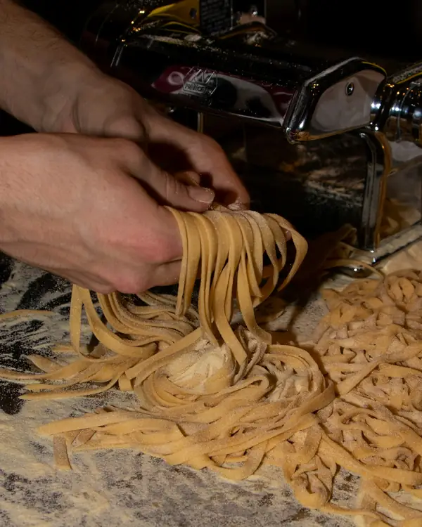Tagliatelle appena tirate che escono dalla macchina