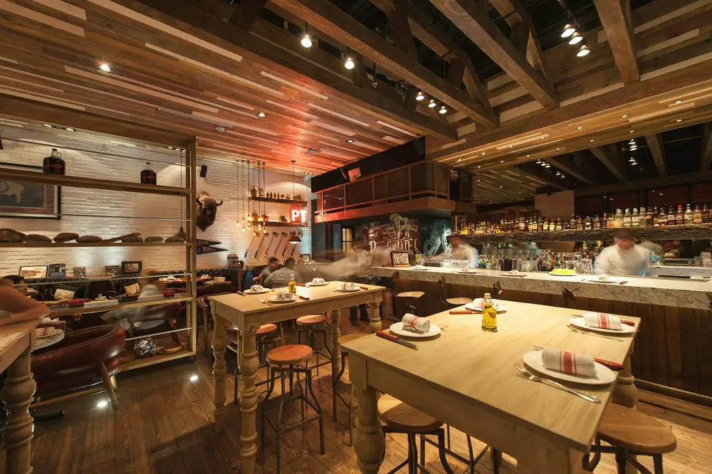 La sala con i tavoli di legno apparecchiati